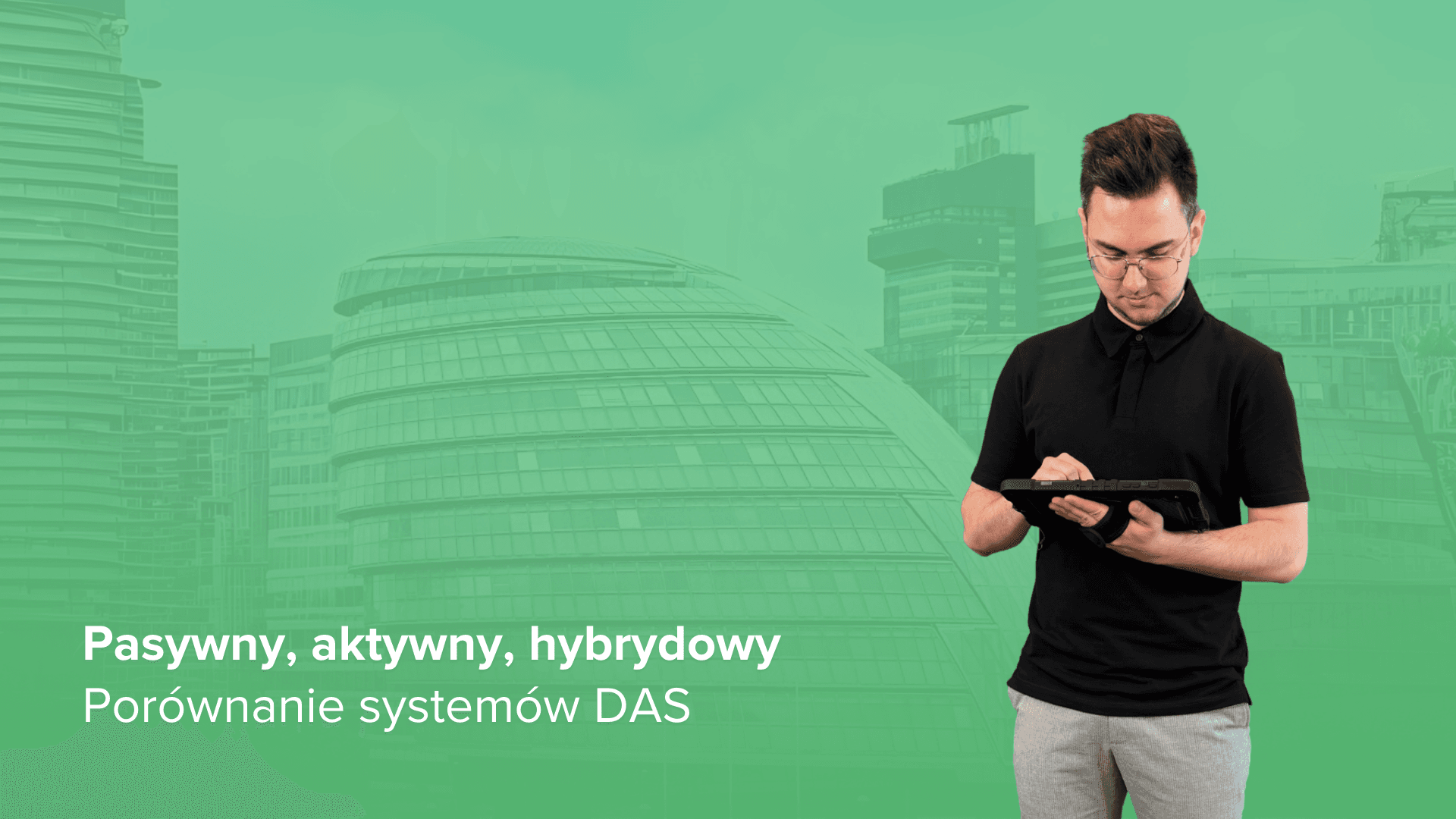 Grafika z napisem „Pasywny, aktywny, hybrydowy. Porównanie systemów DAS”. Po prawej stronie widać mężczyznę w okularach i czarnej koszulce, który obsługuje tablet. Tło z nałożonym zielonym filtrem przedstawia nowoczesną, przeszkloną architekturę o obłych kształtach.